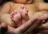 barefoot baby in his mother's hands