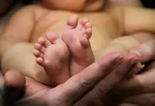 barefoot baby in his mother's hands