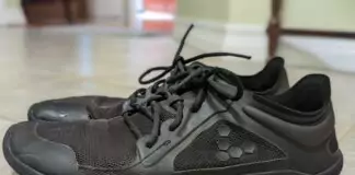 Side view of worn, black minimalist shoes